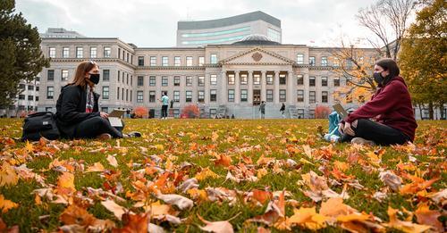 Students sitting on Tabaret lawn in the fall.