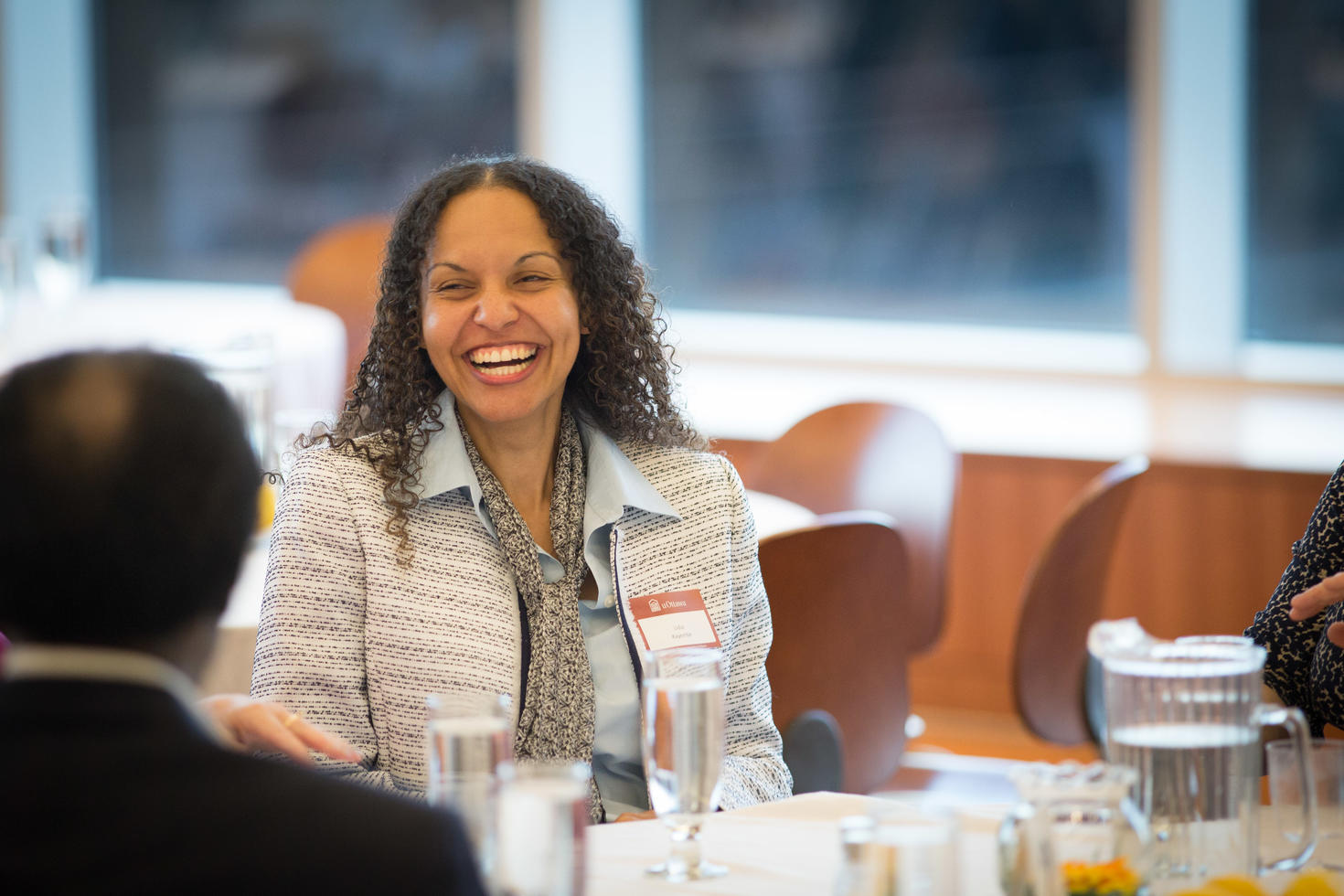 Person smiling sitting at conference table.