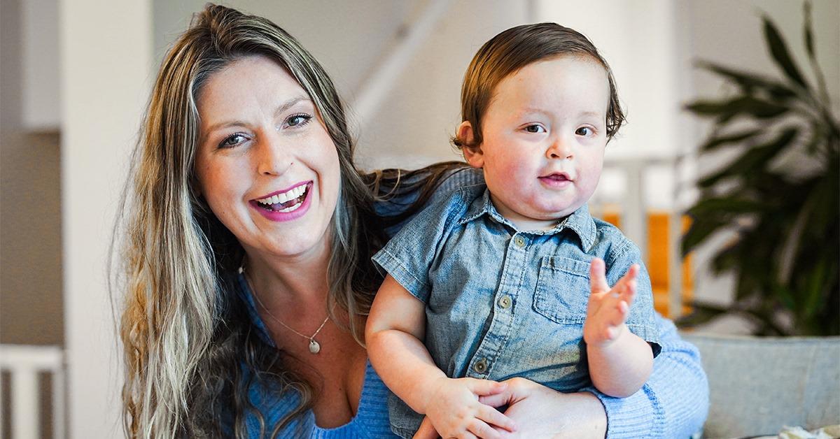 Maman souriant et tenant son fils dans ses bras.
