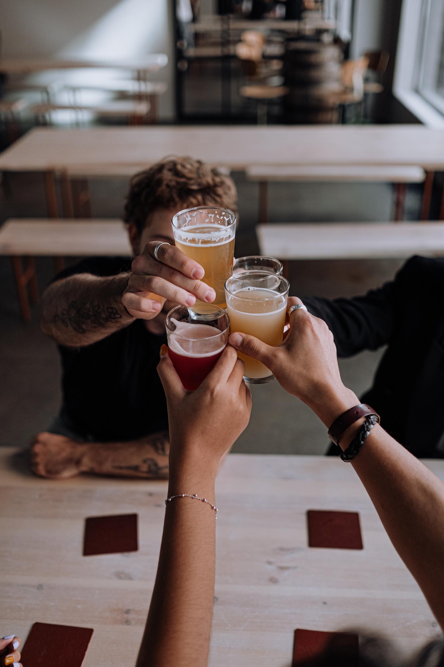 People are clinking beer glasses.