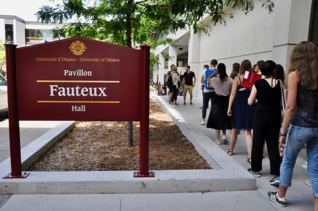 People walking beside Fauteux Hall