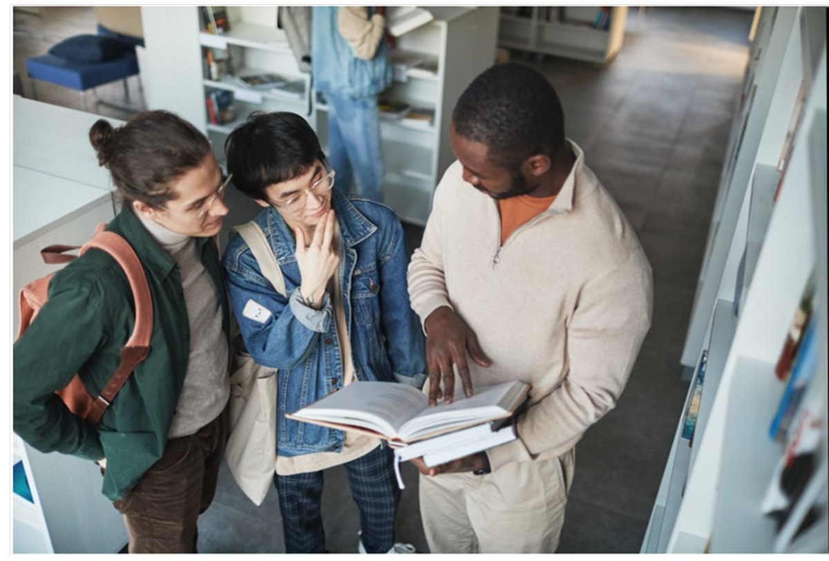 Group of university student looking at a book and talking. Co-op event ad