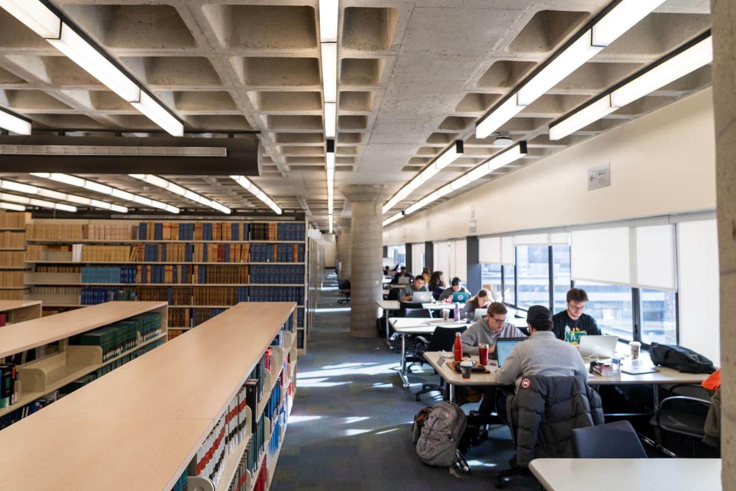 Personnes en train d’étudier à des tables à la bibliothèque