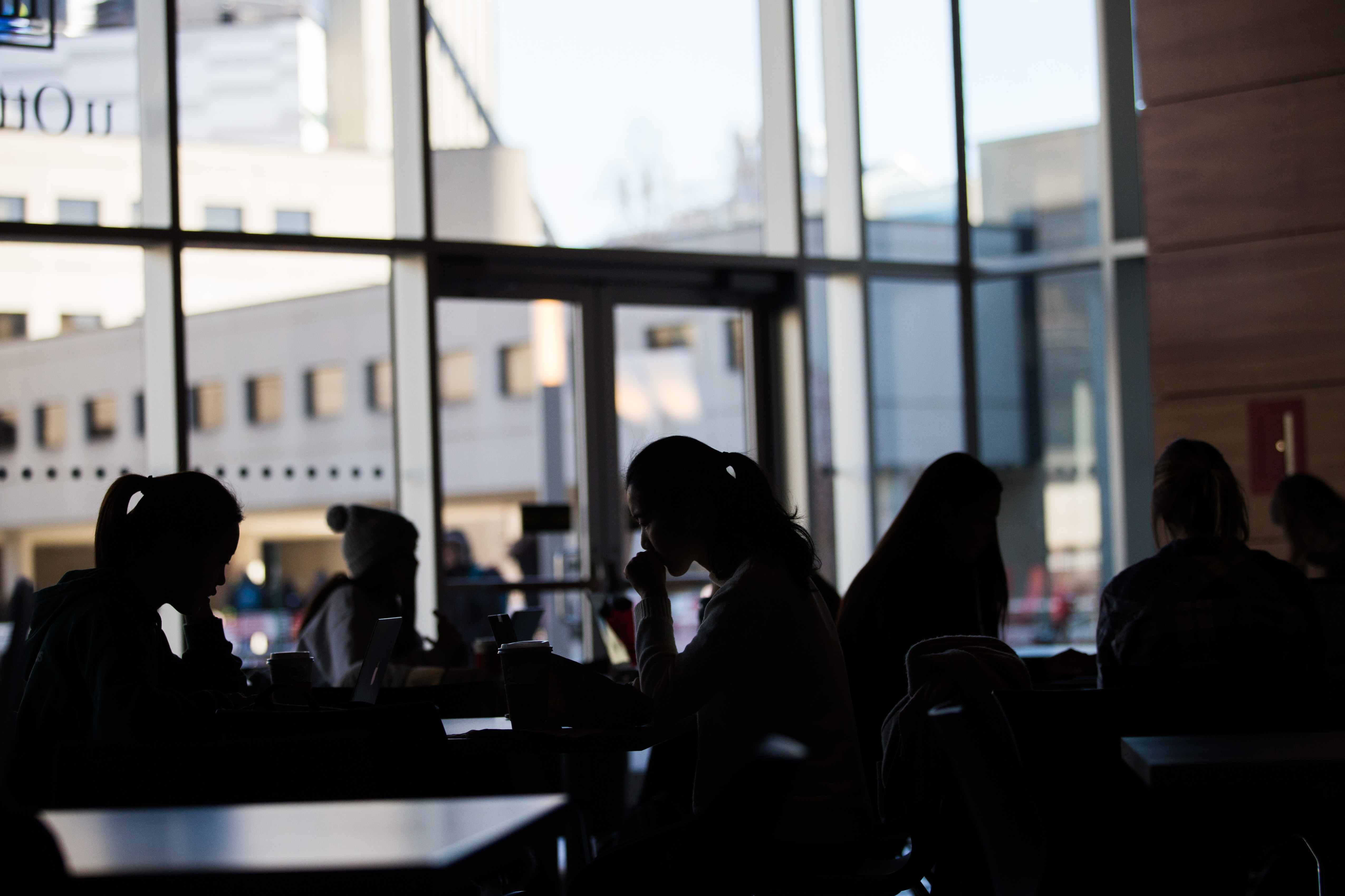 Silhouettes of students in a common space indoors