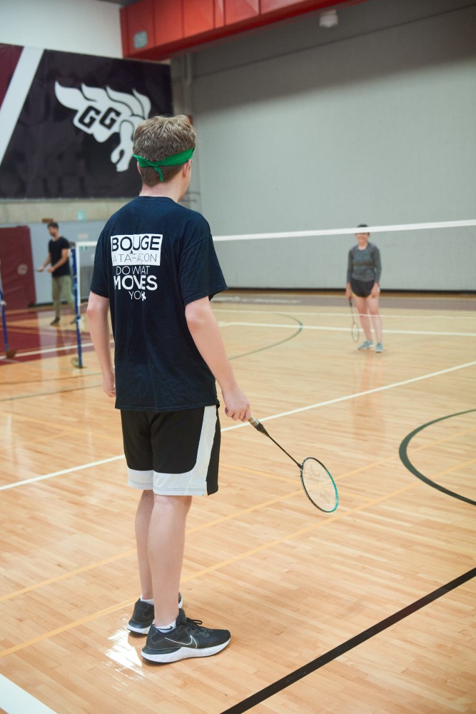 Person waiting on badminton court.