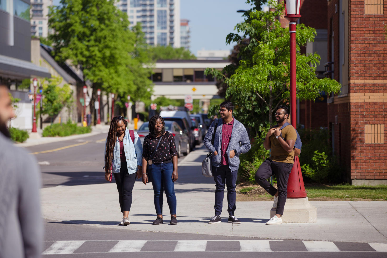 four people crossing the road