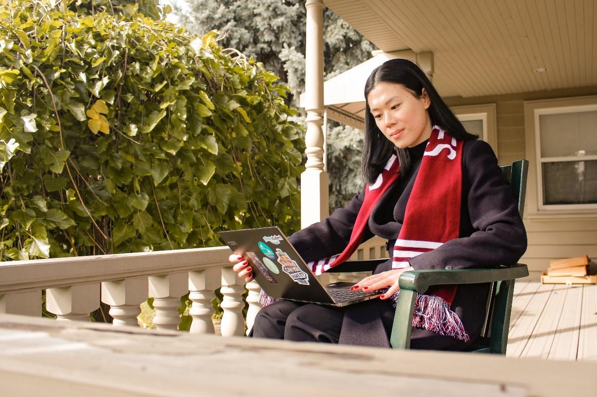 Person sitting with a laptop on her knees