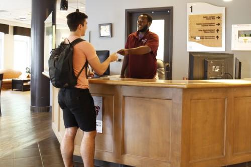 employee serving a student at front desk