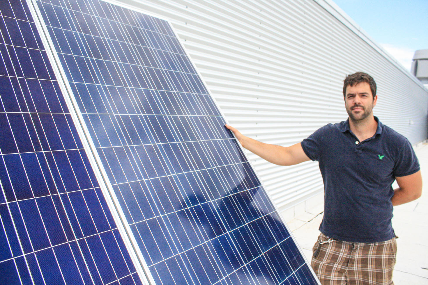 Person holding a solar panel at University of Ottawa to help reduce our greenhouse gas emissions