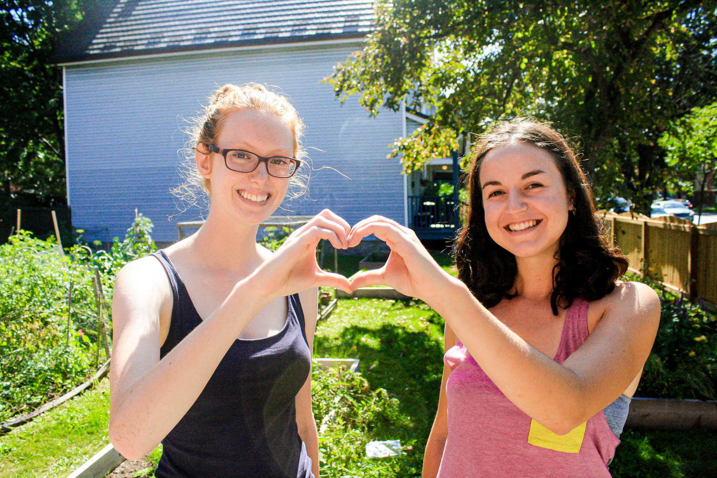 two volunteers join hands to make a heart shape