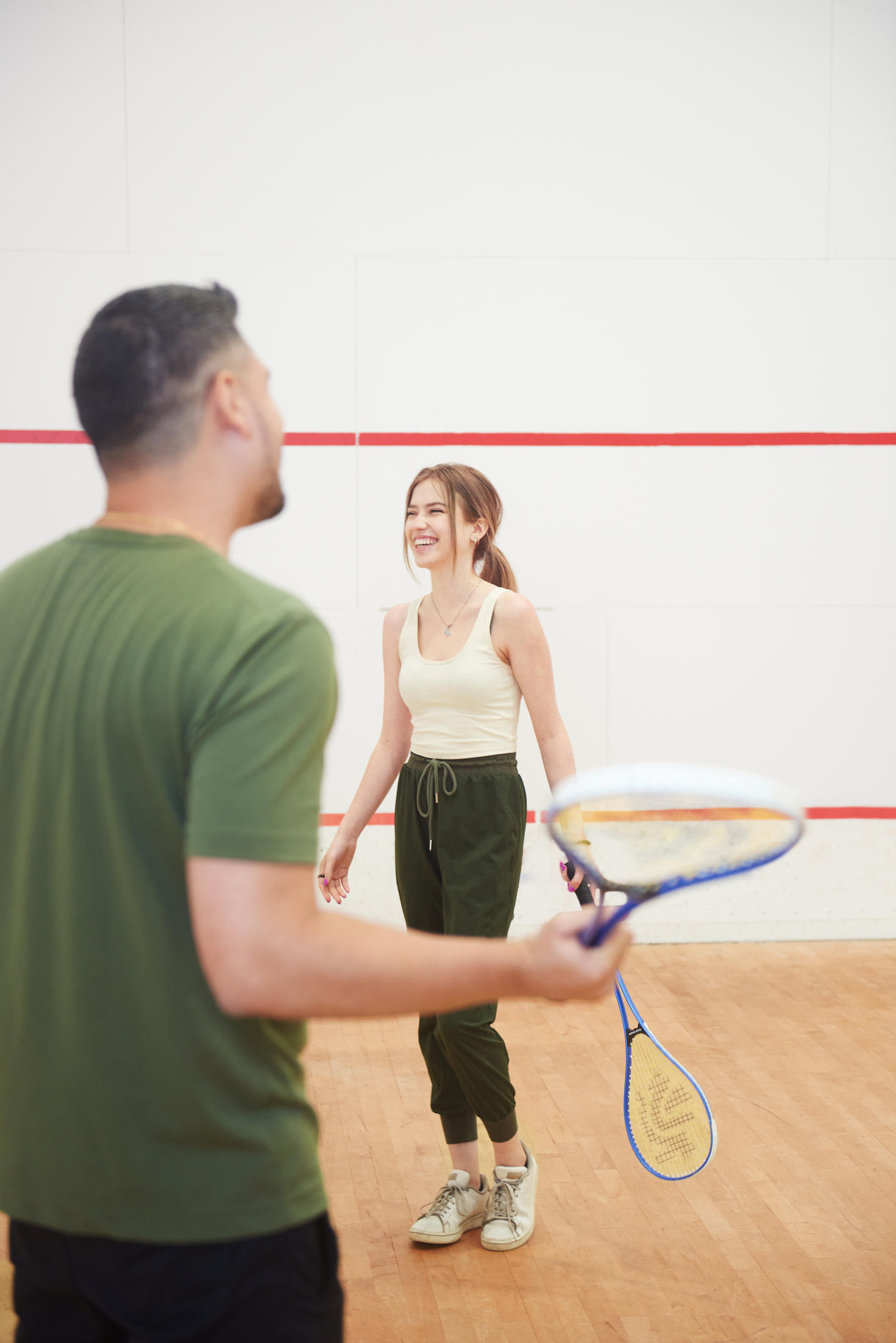 two individuals in a squash court