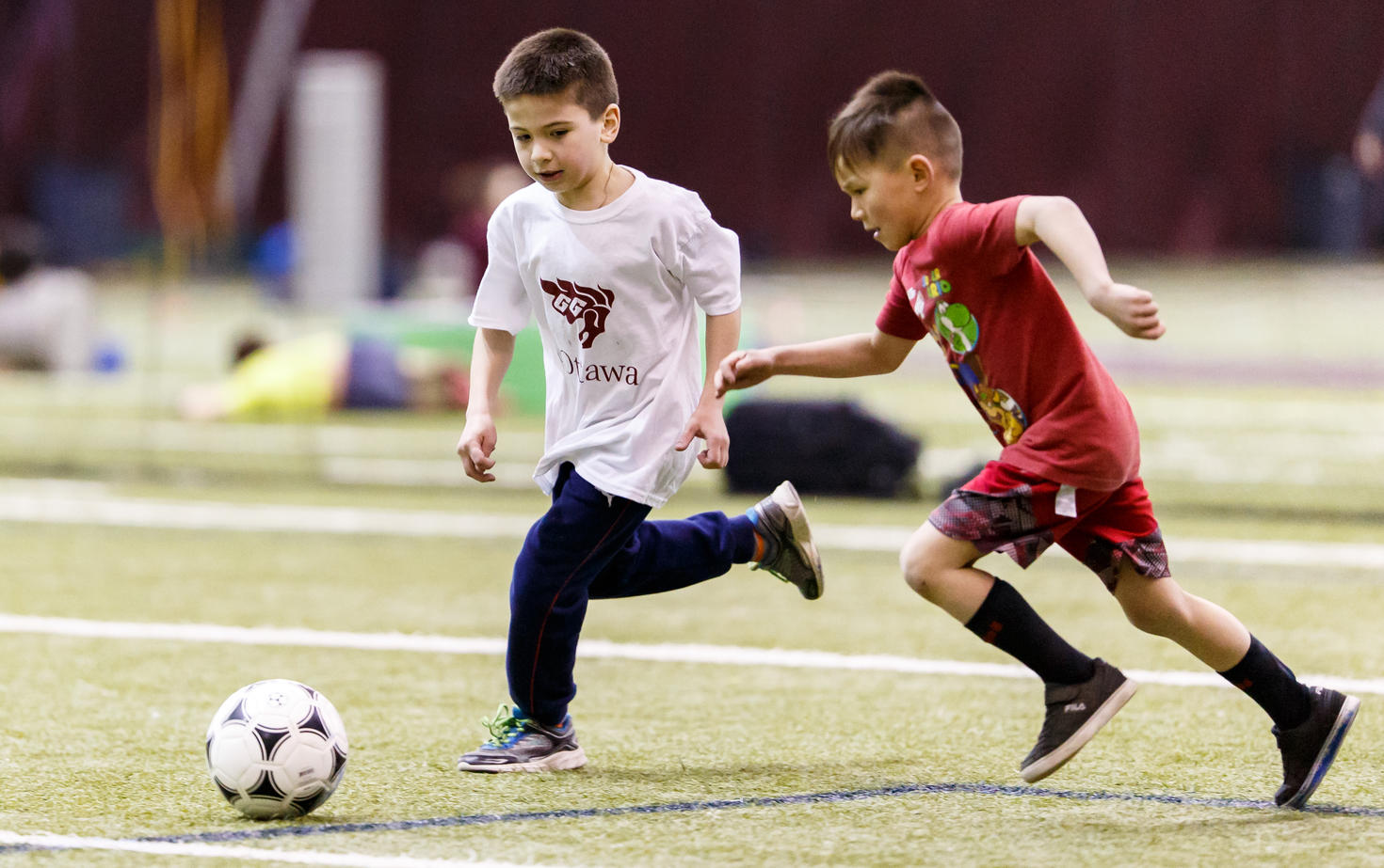 Two kids playing soccer in summer camp