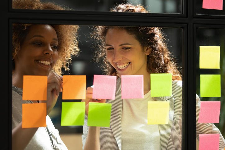 two people standing in front of wall with post-its