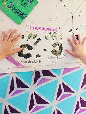 Coordinators and volunteers make handprints on the wall of the store