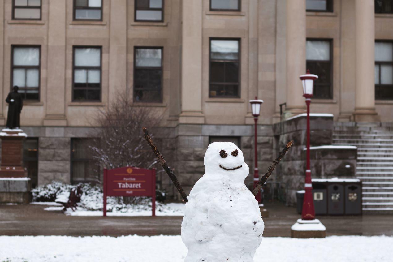 A snowman in front of Tabaret Hall