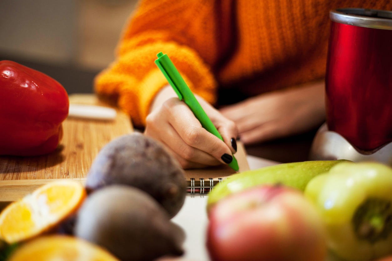 Close up of a person writing a grocery list