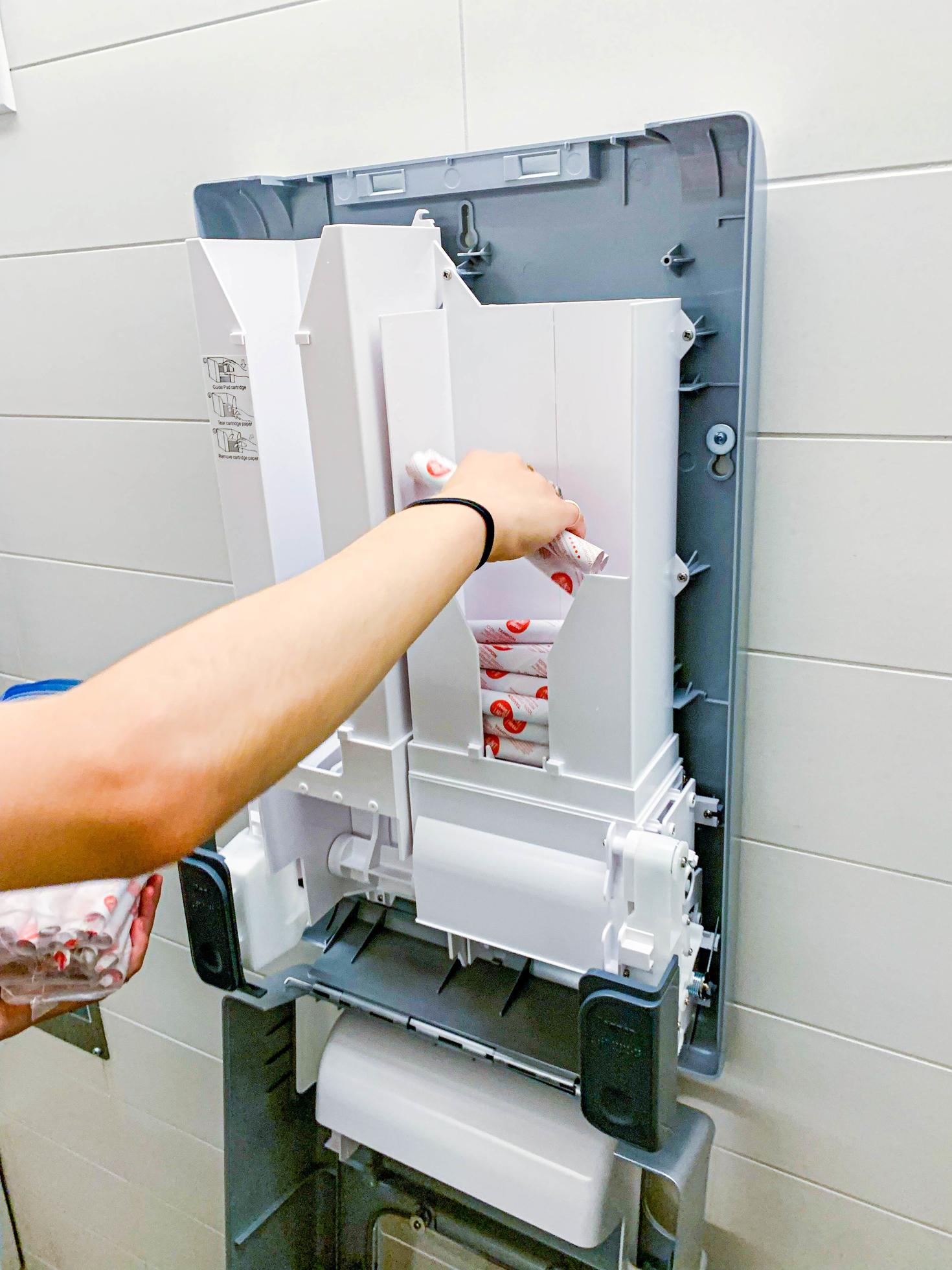 A hand filling up the dispenser.