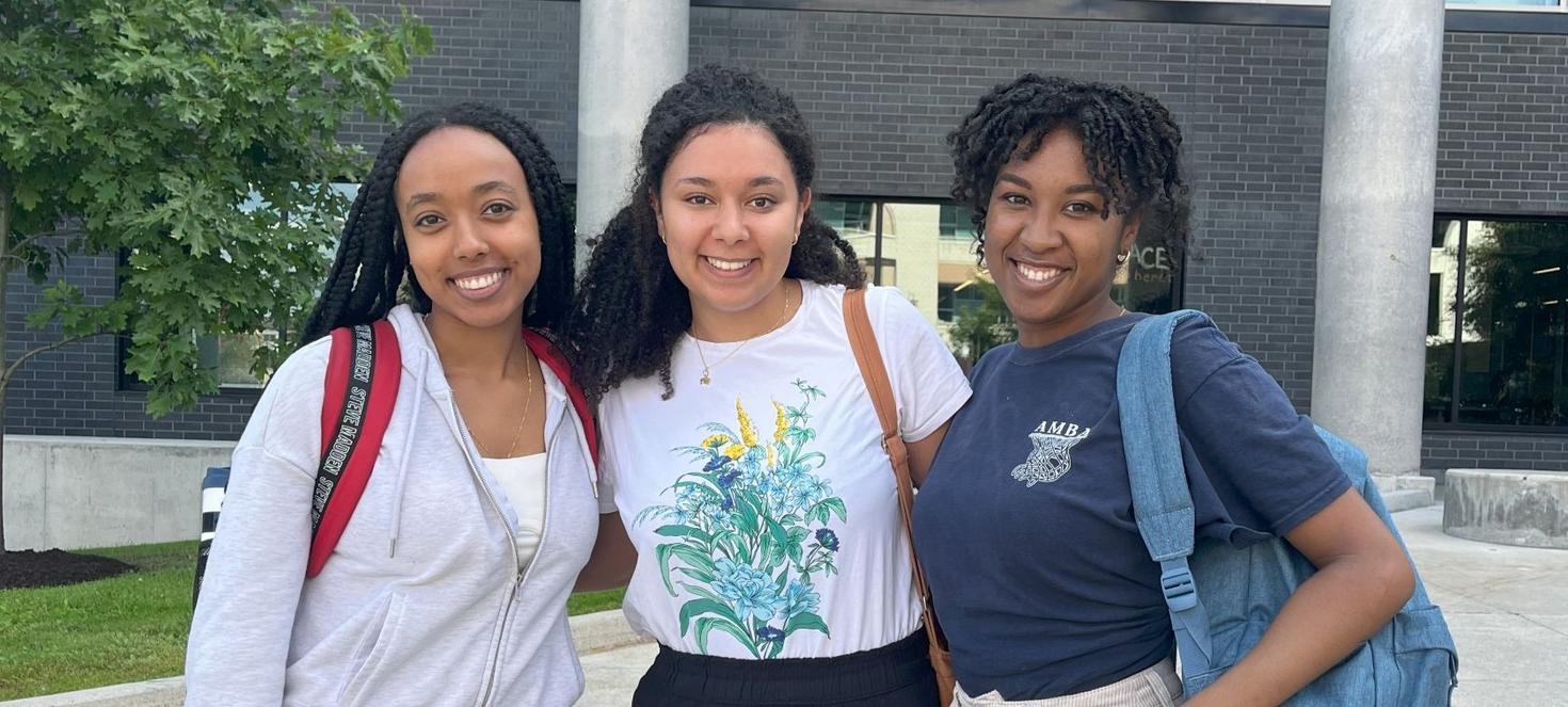 Three female students posing outside the stem complex