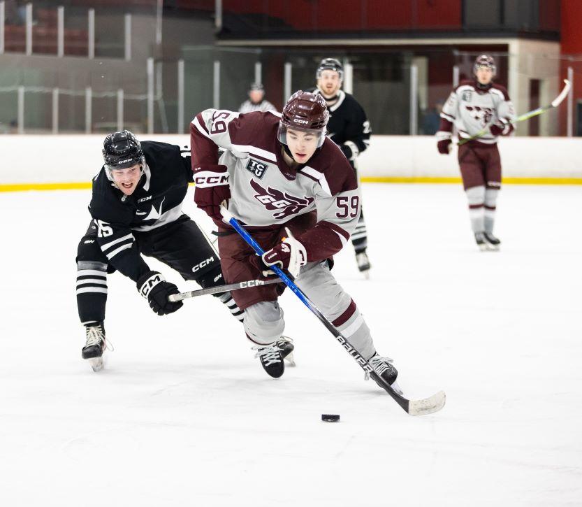 Men's hockey Gee Gees player Mitchell Martin stick handles the puck around opposition players.