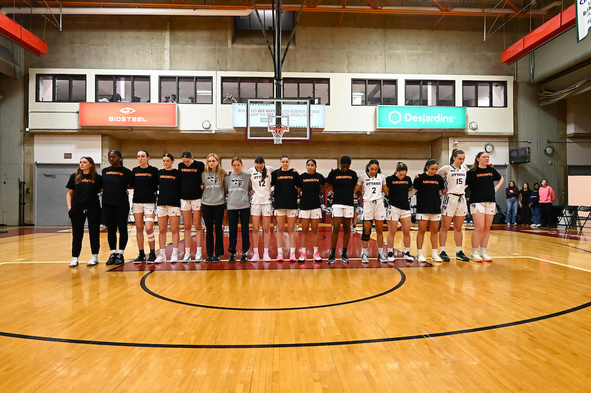Gee-Gees women's basketball players standing on the court, wearing "UBUNTU" t-shirts meaning "I am because we are"