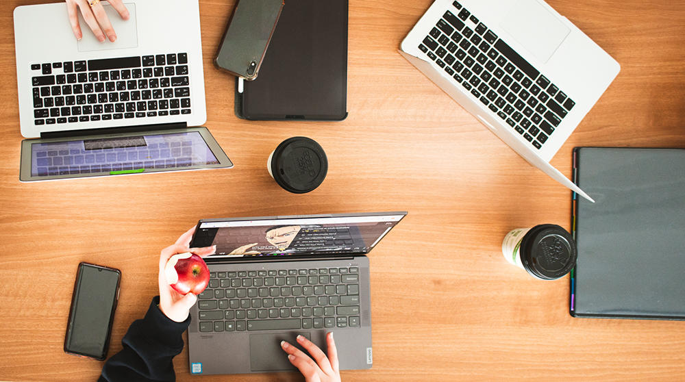 An overhead view of laptops on a table.