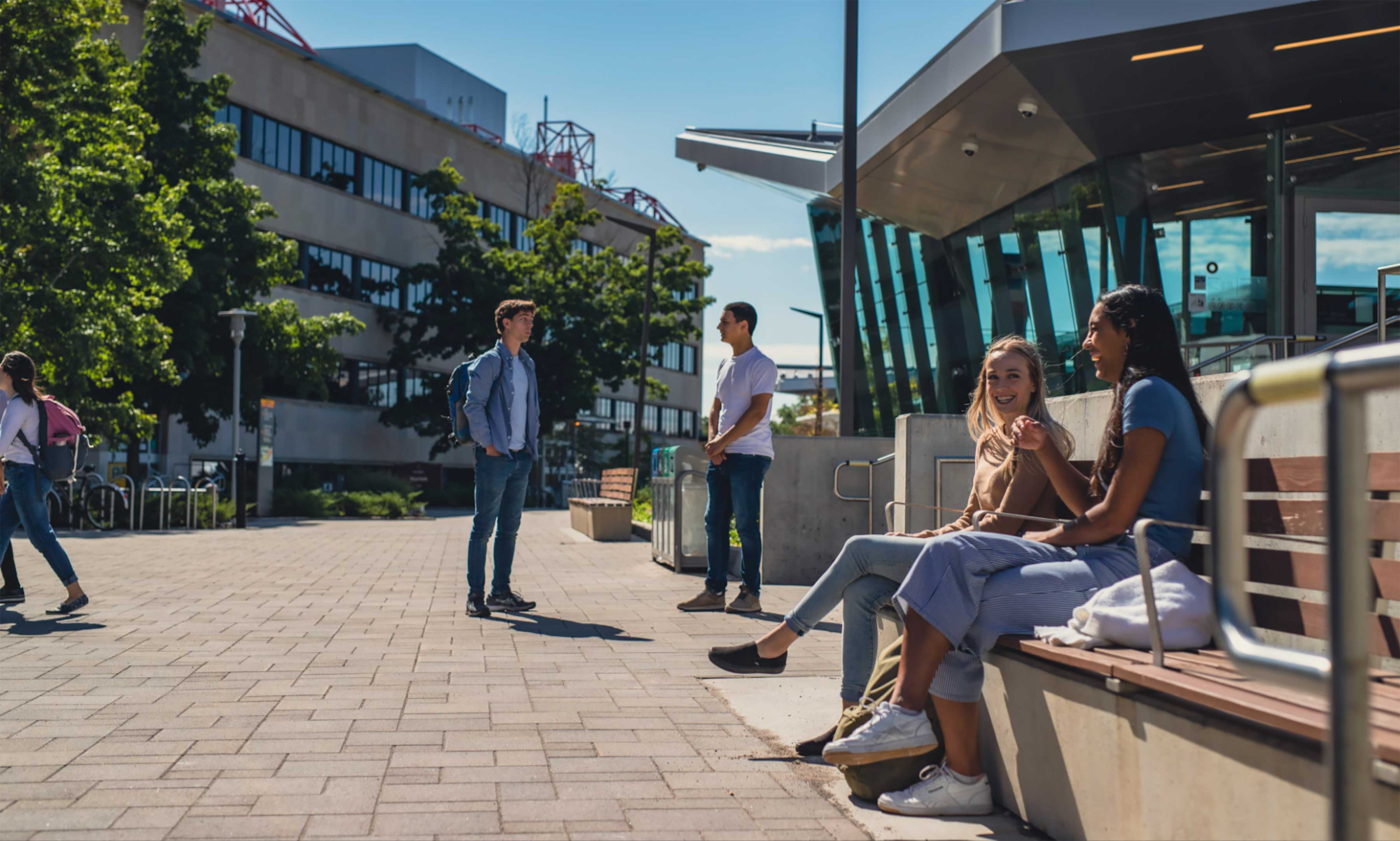 Students sitting on bench outside.