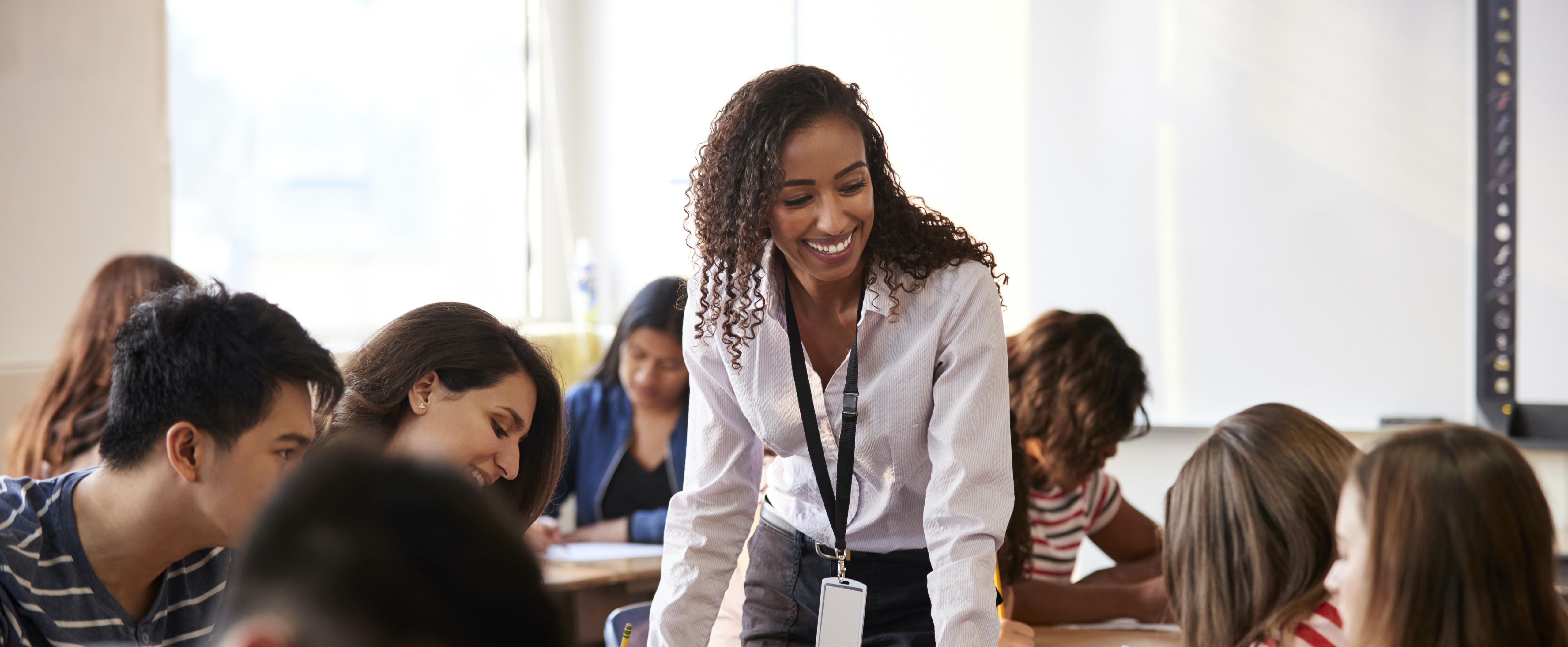 teacher standing in a classroom among students sitting