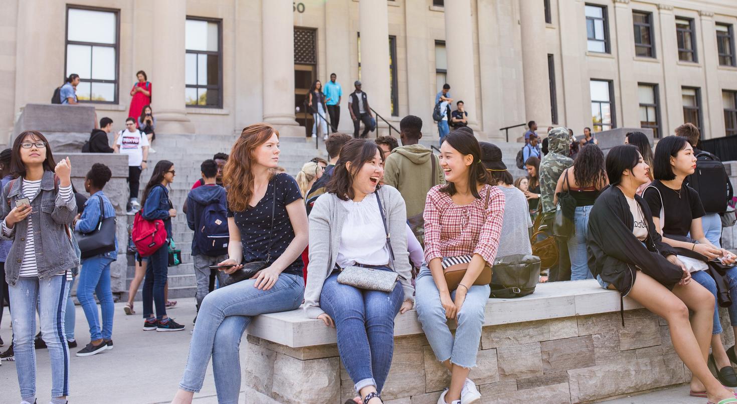 Group of students sitting in front of Tabaret Hall.
