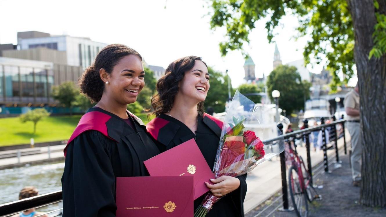 two graduating students posing for a photo