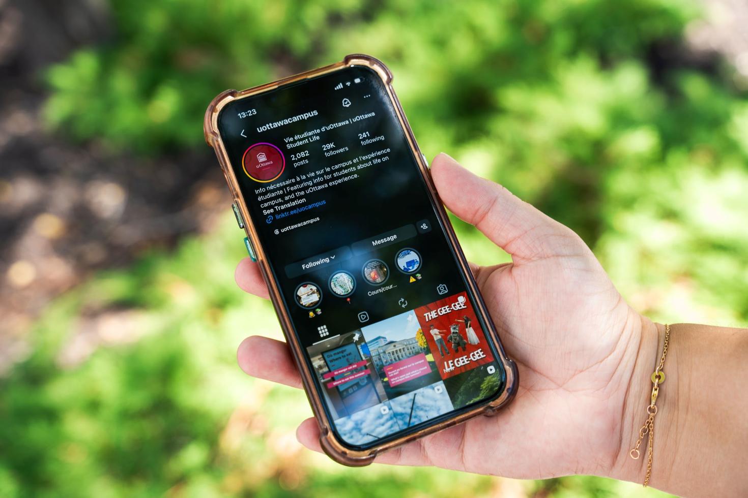 A hand holding an iphone with the @uottawacampus Instagram account on the screen.