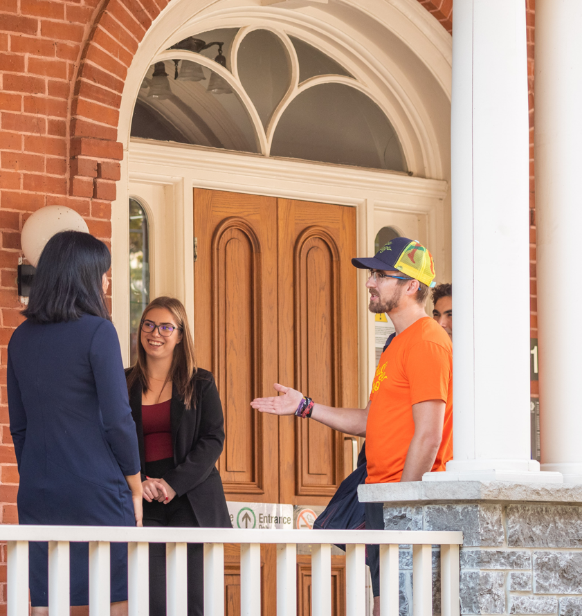 Des gens qui socialisent à l'extérieur de l'Alumni Hall.