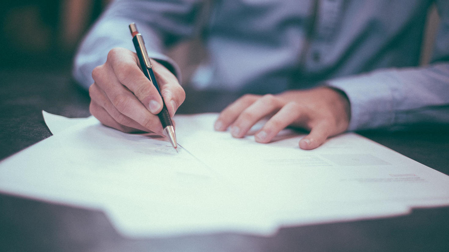 Gros plan d'un homme signant un document