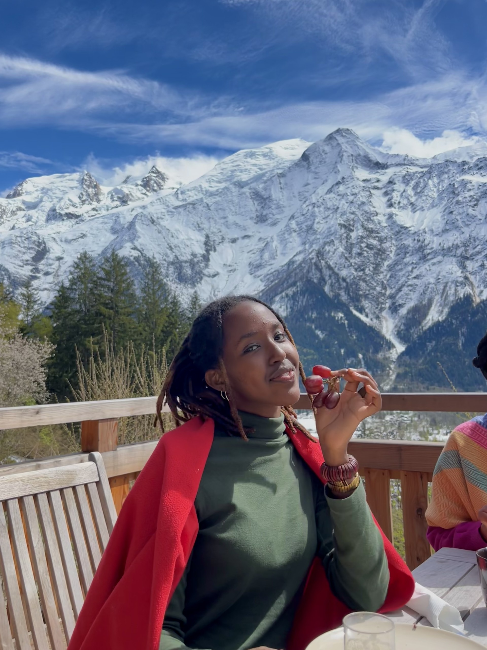 Girl eating grapes with mountain in the background