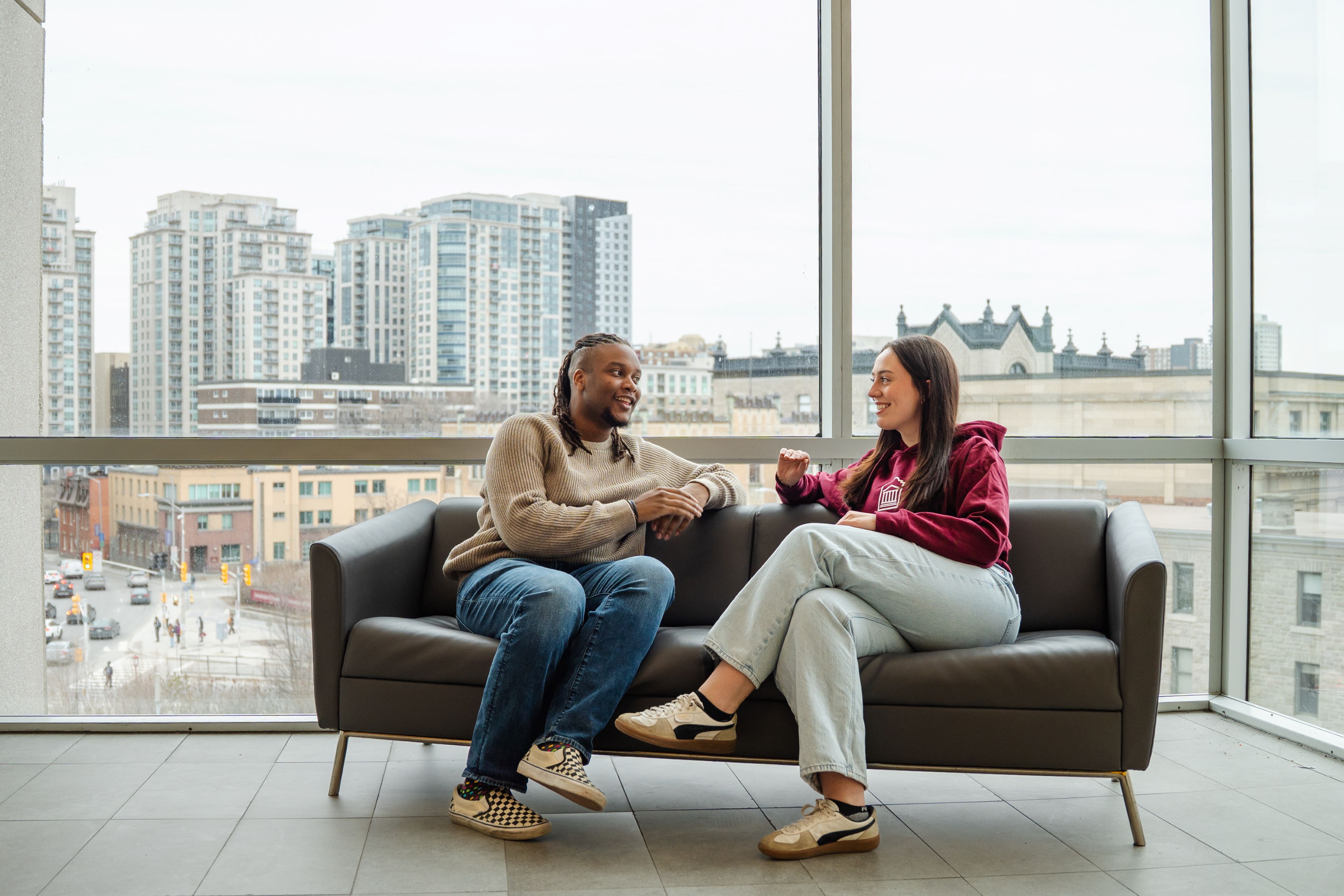 Une étudiante et un étudiant discutent dans le bâtiment Desmarais