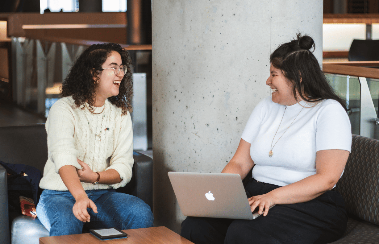 Two students smiling at each other.
