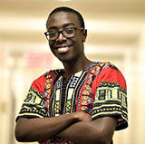 stevesangwa les bras croisés en chemise africaine