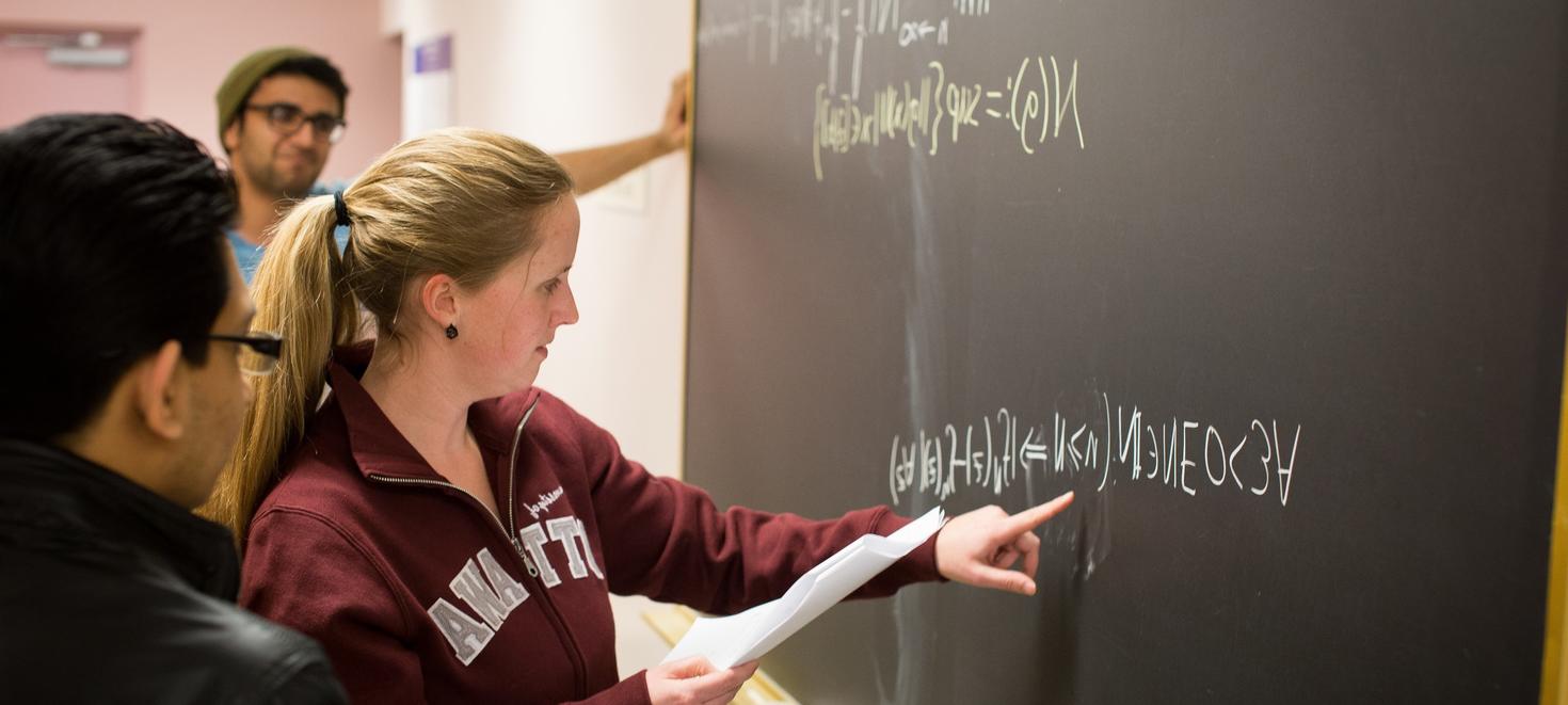 Étudiants devant un tableau noir.