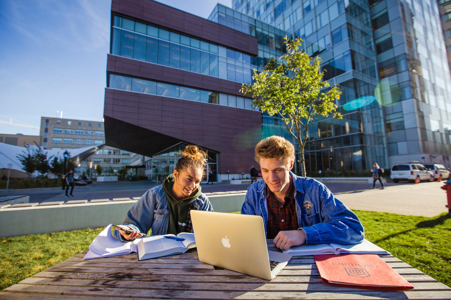 Two students studying, with a laptop and a notebook