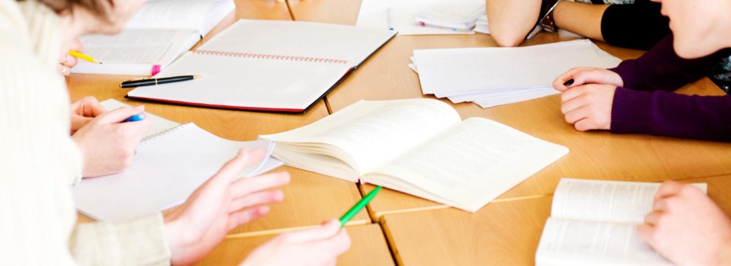 plusieurs mains autour d'une table avec des documents de travail dessus