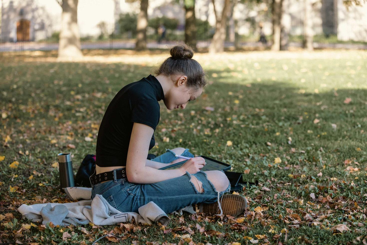 étudiante travaillant assise dans l'herbe