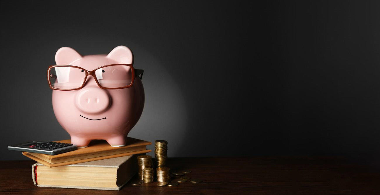 Tirelire posée sur une pile de livres