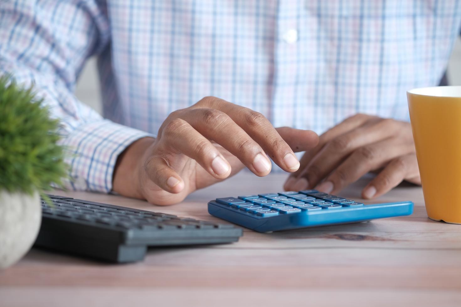 Personne tapant sur une calculatrice.