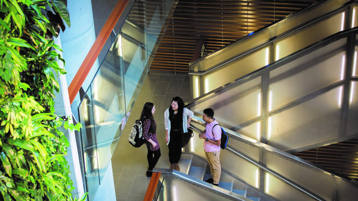 Des étudiants debout près de l'escalier du pavillon des sciences sociales