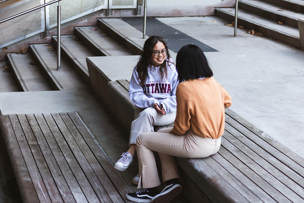 Des étudiants discutent dans les escaliers du campus.