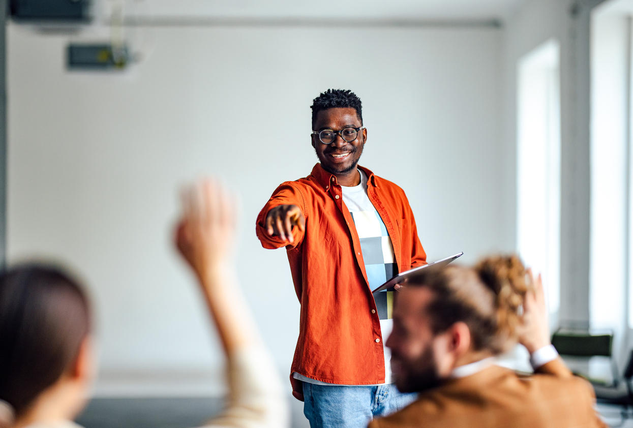 Professeur pointant à un étudiant à la main levée en salle de classe