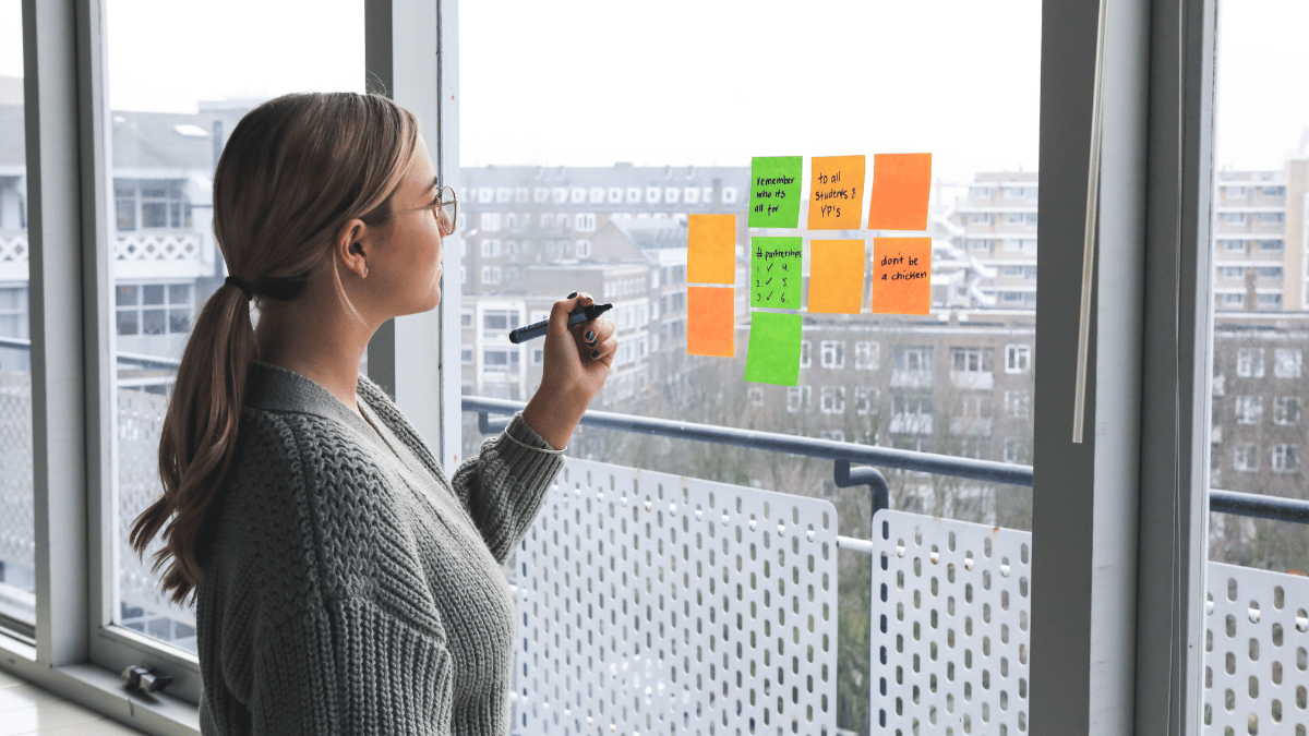 Femme devant une fenêtre avec des notes.