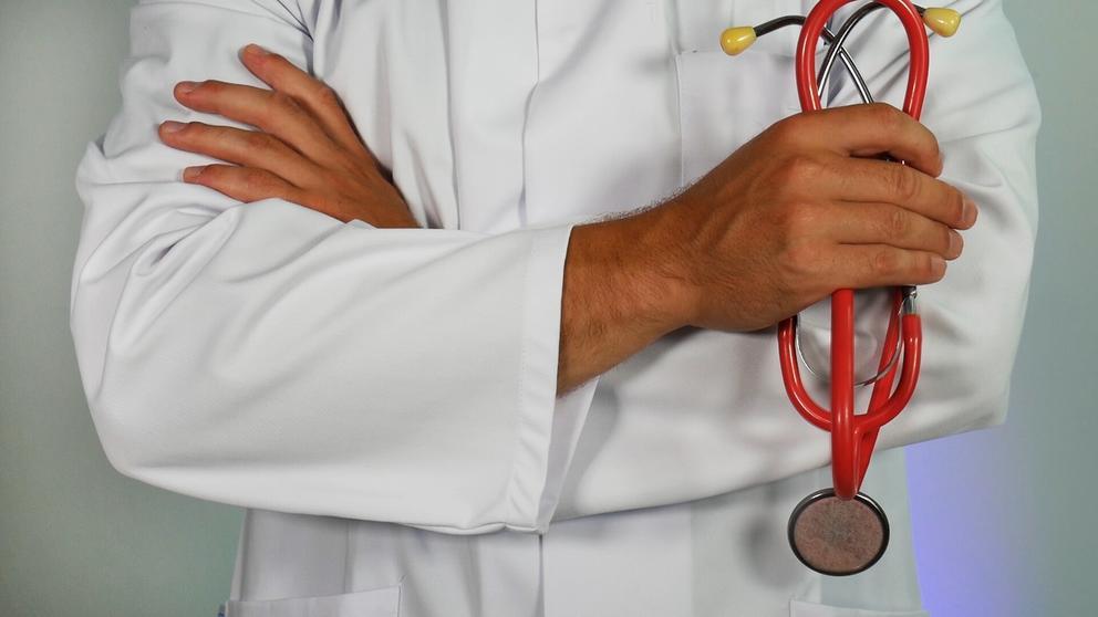 Plan rapproché de la poitrine d'un médecin qui a les bras croisés et tient un stéthoscope