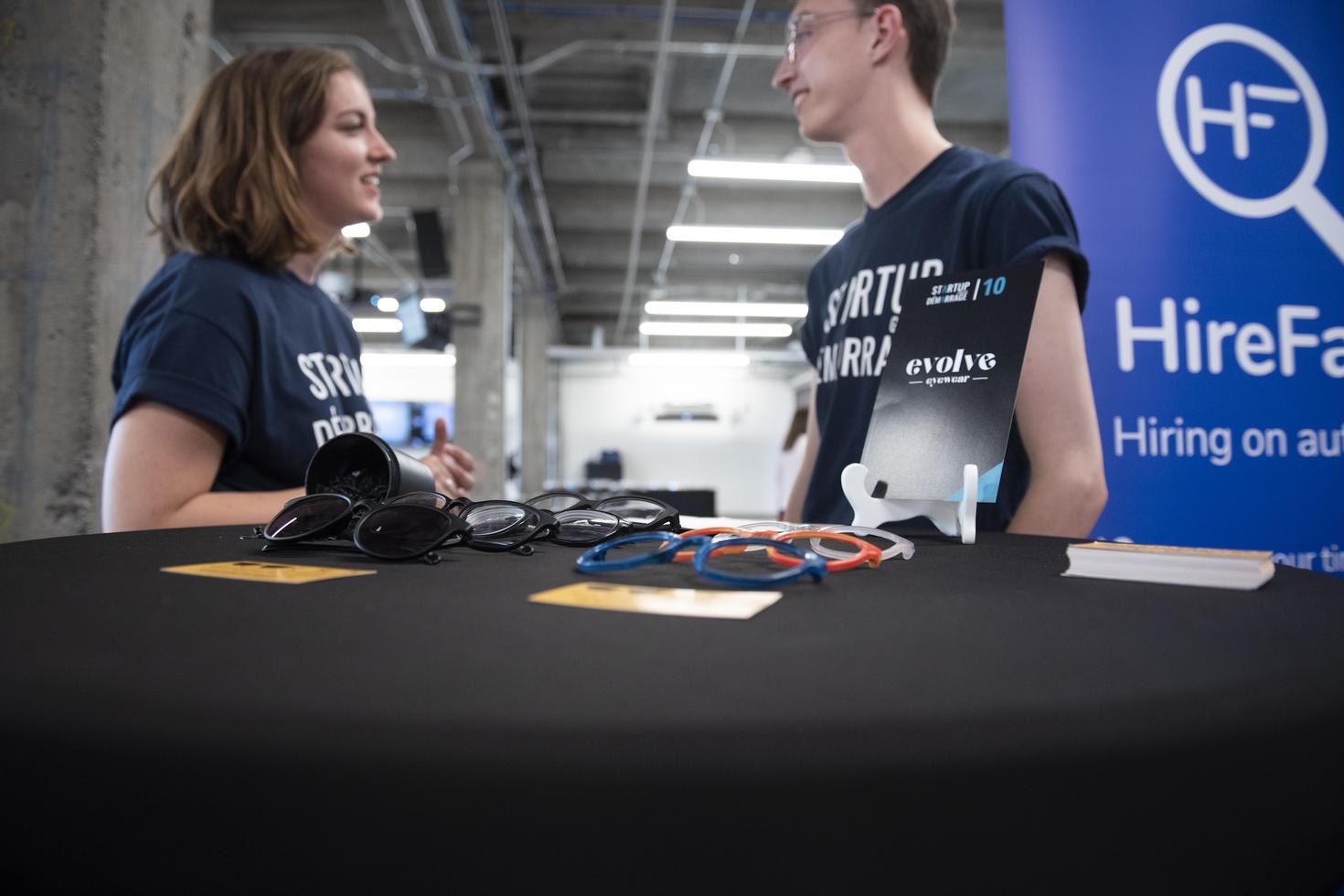 table avec lunettes de soleil avec des étudiants à proximité lors d'un événement