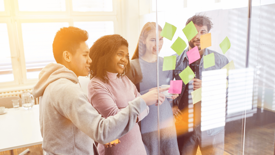 Groupe de participants devant une fenêtre murale avec des post-its