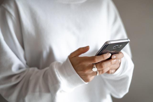 Gros plan sur les mains d'une personne tenant un téléphone portable